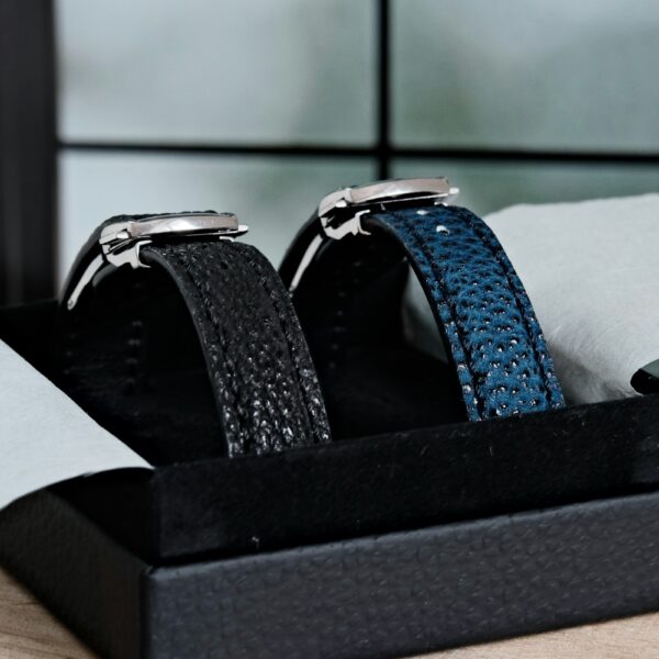 Zwei Uhren mit strukturierten Lederarmbändern in einer Box